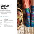 "Dornstich-Socken" steht oben. Links Text mit Material- und Maschenprobeangaben, rechts bunt gestrickte Socken an Füßen.