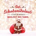 "Der Schokonikolaus ist heute die wichtigste Mahlzeit des Tages." Vor einem funkelnden, unscharfen Hintergrund steht ein Schokoladen-Nikolaus mit roten Kugeln.