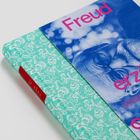 Buch mit blau-pinkem Cover: "Freud" und "erzi...". Grüner Buchrücken mit weißem Blumenmuster.
