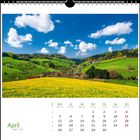 Kalenderseite für April: Wochentage und Daten unter einem strahlend bunten Frühlingslandschaftsfoto mit Hügeln und Blumen.