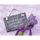 "Gott spricht: Ich will dich segnen und du sollst ein Segen sein. 1. Mose 12,2" auf Tafel, daneben ein Fliederstrauß.