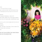 Text beschreibt Mia und Rajah, einen großen Tiger. Illustration zeigt Mia auf Rajah reitend, umgeben von leuchtenden Farben.