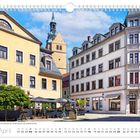 Aprilkalender: Peterstraße mit Fortuna-Brunnen, Kirchturm St. Petri. Historische Gebäude und blauer Himmel.
