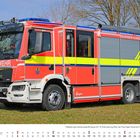 „FEUERWEHR“ steht auf einem leuchtend roten Feuerwehrauto. Darunter ist eine Oktober-Kalenderansicht.