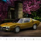 April-Kalenderblatt mit einem goldenen Sportwagen, umgeben von blühenden Bäumen und Steinsäulen.