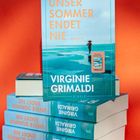 Der Text lautet: "UNSER SOMMER ENDET NIE, VIRGINIE GRIMALDI, ROMAN". Ein Buchstapel vor rotem Hintergrund.