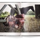 Text: "THE ULTIMATE BOOK", "EQUESTRIAN". 
Ein Sattel ruht auf einem Holzzaun, im Hintergrund weidet ein Pferd.