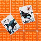 Zwei Karten mit Illustrationen von Meerestieren, darunter ein Wal und ein Orca, auf orangefarbenen Kartenhintergründen.
