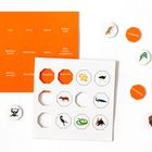 Oranges und weißes Spielbrett mit Tiernamen und passenden runden Kärtchen mit Tierbildern.