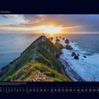 10 Oktober. Ein Leuchtturm auf einer Klippe bei Sonnenuntergang, mit Meer und Felsen drumherum. Darunter: Kalender für Oktober.
