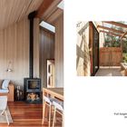 "Full-height glazing on two sides floods the interior with natural light. 9."  
Gemütlicher Raum mit Holzofen, Sesseln und Sofa.