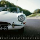 Text: "DE-61-44", "Jaguar E-Type", "4". Kalender zeigt Tage und Wochen; weißer Oldtimer auf Landstraße.