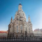 Frauenkirche am Neumarkt, darunter ein Kalendarium für April. Die Kirche ist prächtig und von blauen Himmel umgeben.