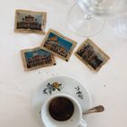 Kaffeetasse, Untertasse mit Blumen, Löffel; 4 Zuckerpäckchen mit Aufschriften: Basilica, Colosseo, San Pietro, Foro Romano.