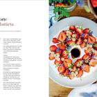 "Rezepte für Erdbeertorte und Jordgubbstårta, umgeben von frischen Erdbeeren und Blumen auf einem Holzuntergrund."