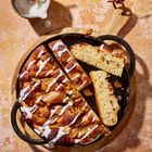 "Staub" auf gusseiserner Pfanne. Apfel-Zimt-Brot mit Zuckerguss. Holzbrett. Schüssel mit weißer Glasur und Löffel.