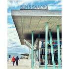 Oben steht "SUN & SNACKS". Ein modernes Gebäude, daneben gehen zwei Personen auf wolkigem Weg.