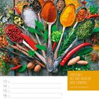 „Vielfalt ist die Würze des Lebens.“ – Ernst von Wildenbruch. Gewürze auf Löffeln, bunte Zutaten auf Holzoberfläche.