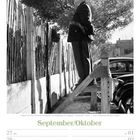 Kalenderseite September/Oktober 2027. Ein Polizist steht auf einer Trittleiter und schaut über einen Zaun.