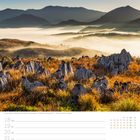 Landschaft im Akiyoshidai-Quasi-Nationalpark, Yamaguchi. Kalenderwoche 42 im Oktober. Nebel, Hügel, Gras und Felsen.