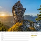 43. Woche Oktober 2027. Sonnenaufgang in den Ammergauer Alpen, Bayern. Ein imposanter Felsen vor blauen Himmel.