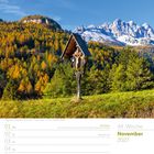 Text: "November 2027, Wegkreuz im Fassatal - Dolomiten - Trient - Italien, Allerheiligen, Allerseelen (A)."

Ein Wegkreuz vor herbstlichen Bäumen und schneebedeckten Bergen.