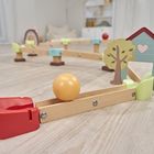 Holzeisenbahnstrecke mit gelber Kugel, Haus und Baum aus Holz. Verspielte, helle Umgebung mit kindlichem Design.