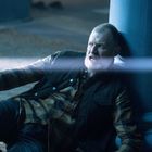 Ein Mann mit Bart sitzt erschrocken und angelehnt an einer Säule, während ein heller Lichtstrahl ihn trifft.