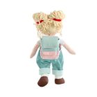 Puppe von hinten, trägt einen hellblauen Rucksack und hellblaue Latzhose. Haare aus Wolle, gebunden mit roten Bändern.