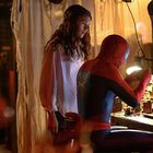 Ein Mann im Spiderman-Anzug sitzt an einem Tisch mit vielen Werkzeugen, während eine Frau daneben steht.