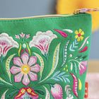 Keine erkennbaren Texte. Farbige Stickerei mit floralen Motiven auf grünem Stoff.