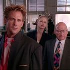 Drei Personen in einem Büro; ein Mann mit wuscheligem Haar im Vordergrund, Frau und älterer Mann im Hintergrund.