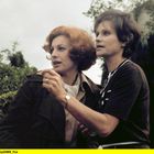 20010208160656SWR_F02. Zwei Frauen im Gespräch, in einem Garten, umgeben von Bäumen und Sträuchern.