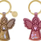 Zwei Engel-Schlüsselanhänger, einer beige mit Taube, der andere rosa mit Herz, an goldenen Ringen mit Symbolen.
