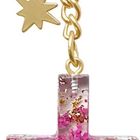 Der Text "COPPENRATH" steht auf einem goldenen Schlüsselring. Ein Kreuz mit lila und goldenen Elementen hängt daran.