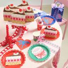 Eine bunte Feierdekoration mit Kuchenillustrationen, Partybechern, Geschenktüten und Schleifen.