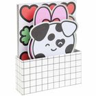 Ein Kasten mit Gittermuster hält Notizblöcke, einer zeigt ein lachendes Gesicht mit Herzfleck und Hasenohren.