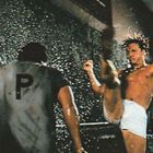 Ein Mann mit einem "P" auf dem Rücken wird von einem anderen Mann mit einem hohen Tritt angegriffen.