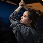 Es gibt keine sichtbaren Texte. Eine Person in einem grauen Hoodie ist mit Kabelbindern an einem blauen Auto gefesselt.