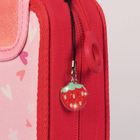 Ein rotes Etui mit einem Erdbeeranhänger am Reißverschluss, pinke und rote Herzen im Hintergrund.