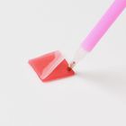 Ein rosa Stift berührt ein Stück roten Wachses, teilweise von Folie bedeckt, auf hellem Hintergrund.