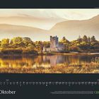 „Oktober“ und ein Kalendarium. Eine Burg am Wasser bei Sonnenuntergang, umgeben von herbstlichen Bäumen.