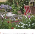 Mai 2027. Ein Garten mit Holzbank, Tisch und Strandkorb, umgeben von vielen weißen und bunten Blumen.