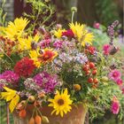 Texte: "Landlust", "Oktober", "DIE KNOLLENSONNENBLUME". Blumenstrauß in Tonvase auf Holztisch.