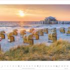 Kalenderseite 9 - 2027. Strandkörbe bei Sonnenuntergang, ein Pier mit Gebäude im Hintergrund, Dünen im Vordergrund.