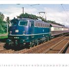 "VIERSEN" auf einem Bahnhofsschild, ein blauer Zug der DB steht auf den Gleisen, umgeben von Bäumen. Darunter ein Kalender.