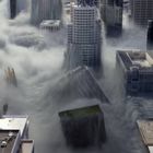 Eine Stadt wird von massiven Wellen überflutet, Gebäude versinken im Wasser.