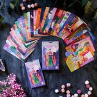 "Darling Weirds ORACLE" steht auf einer Spielkarte. Bunte Illustrationen mit Menschen, Umgebungen und mystischen Elementen.