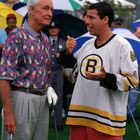 Zwei Männer unterhalten sich auf einem Rasen mit geöffneten Regenschirmen im Hintergrund.