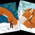 Links springt ein Fuchs durch den Schnee, rechts schläft ein Fuchs eingerollt. Im Hintergrund Tannenzweige.